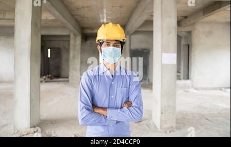 Concetto di ritorno al lavoro, apertura di cantieri dopo la pandemia covid-19 - ritratto di sicuro lavoratore di costruzione in un casco da costruzione Foto Stock