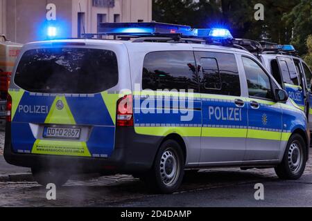 Dresda, Germania. 8 ottobre 2020. Due veicoli della polizia con luci blu lampeggianti sono diagonalmente sfalsati in un sito di implementazione. Credit: Tino Plunert/dpa-Zentralbild/ZB/dpa/Alamy Live News Foto Stock