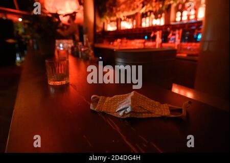 Amburgo, Germania. 8 ottobre 2020. ILLUSTRAZIONE - UNA guardia bocca-naso è sdraiata sul banco di una barra nello Schanzenviertel. Credit: Jonas Walzberg/dpa/Alamy Live News Foto Stock