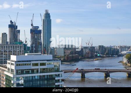 Guardando verso ovest sul Tamigi di Londra, sul ponte Vauxhall, verso la centrale elettrica di Battersea, con sviluppo residenziale adiacente al fiume Foto Stock