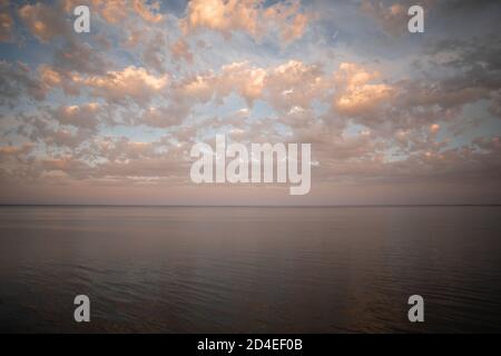 Tramonto dorato con cielo colorato e acqua nel lago riflesso di sera Foto Stock