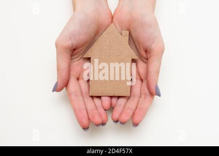 Casa di carta in mani femminili. Concetto di casa di famiglia Foto Stock