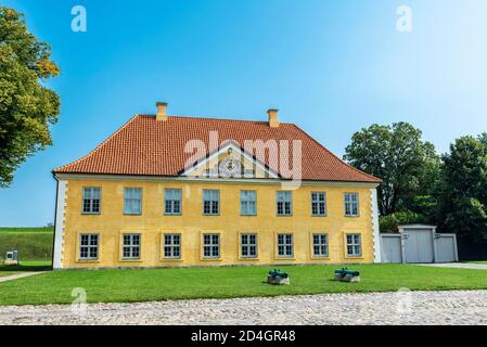 Facciata della Casa del Comandante con due vecchi cannoni a Kastellet (la Cittadella), Copenhagen, Danimarca Foto Stock