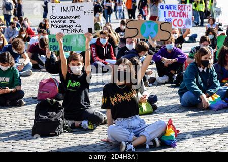 Roma, Italia. 09 ottobre 2020. I manifestanti si siedono mentre tengono i cartelli in Piazza del Popolo durante la dimostrazione. Studenti, cittadini e attivisti del "venerdì per il futuro" hanno partecipato allo sciopero nazionale sul clima a Roma, per chiedere alla classe politica di agire contro il degrado climatico e l'inquinamento ambientale. Credit: SOPA Images Limited/Alamy Live News Foto Stock