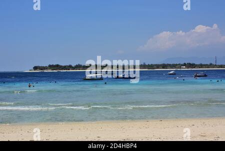 Vista verso est attraverso le acque blu limpide verso Gili meno, foto scattata sulla spiaggia di Gili Trawangan, Indonesia Foto Stock