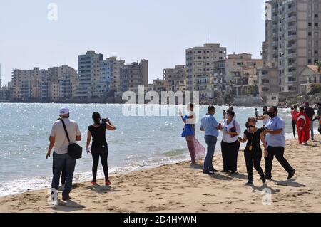 Famagosta, Cipro del Nord. 8 Ott 2020. Questa foto, scattata l'8 ottobre 2020, mostra le persone sulla spiaggia nella località balneare abbandonata di Varosha, nella Repubblica turca di Cipro del Nord (TRNC), catturando questo giorno storico, quando il pubblico ha accesso a questa zona recintata di Famagosta per la prima volta in 46 anni. Varosha è stata lasciata intatta per decenni, sigillata dalle autorità turche dopo la guerra di Cipro del 1974, quando i suoi abitanti principalmente greco-ciprioti sono fuggiti, e l'isola è stata divisa. (Foto di Selim KUMBARACI / Pasedembo / Alamy Live News) Foto Stock