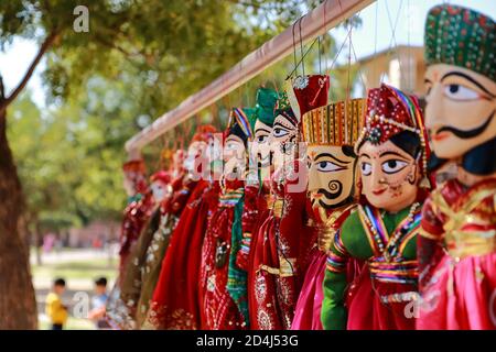 Colorati cuccioli a forma di volto umano che indossano abiti colorati appesi Il muro in Rajasthan India il 21 febbraio 2018 Foto Stock