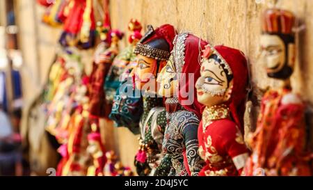 Colorati cuccioli a forma di volto umano che indossano abiti colorati appesi Il muro in Rajasthan India il 21 febbraio 2018 Foto Stock