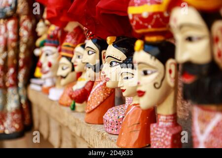 Colorati cuccioli a forma di volto umano che indossano abiti colorati appesi Il muro in Rajasthan India il 21 febbraio 2018 Foto Stock