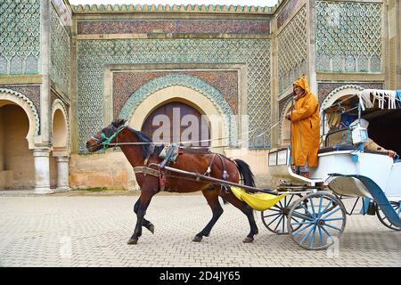 Pullman che passa di fronte al cancello della città di Meknes Foto Stock