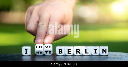 La mano trasforma i dadi e cambia l'espressione 'odio Berlino' in 'amo Berlino'. Foto Stock