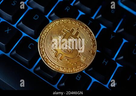 Bitcoin sulla tastiera compuer in background, simbolo di elettronici di denaro virtuale e data mining cryptocurrency concetto. Coin moneta crypto bitcoin giace sul Foto Stock