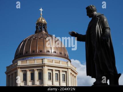 04 ottobre 2020, Berlino: La cupola dello Stadtschloss con la croce dorata che splende al sole sulla sua cima può essere vista accanto al monumento ad Albrecht Thaler (1752-1828) dallo scultore Christian Daniel Rauch o Hugo Hagen, che si trova sulla Schinkelplatz. Foto: Soeren Stache/dpa-Zentralbild/ZB Foto Stock