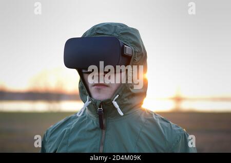 giovani giocatori con cuffie per realtà virtuale e in un ambiente verde giacca protettiva durante una simulazione di una situazione di combattimento Foto Stock