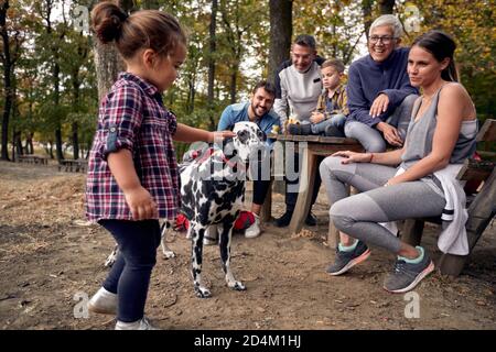 Una famiglia felice e il loro cane in bei momenti in la foresta in una bella giornata d'autunno Foto Stock