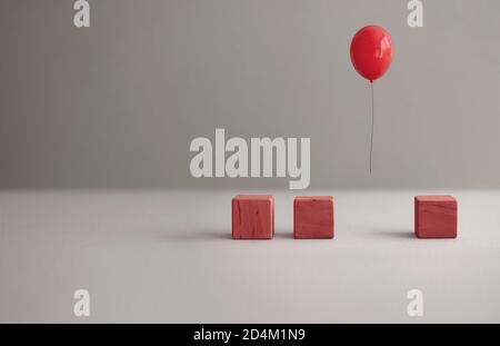 Palloncino rosso a mezz'aria tra i cubetti di legno Foto Stock