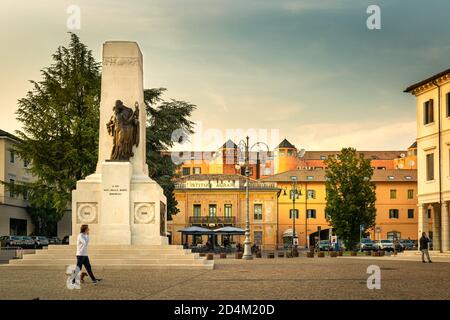 Piazza centrale della città di Montebelluna, Treviso, Italia. Monumento alla prima guerra mondiale e la facciata dell'antico Istituto agricolo Foto Stock