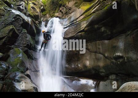 Vista posteriore dell'uomo che abbellendo la cascata nel Canyon di Cypress Creek. Foto Stock