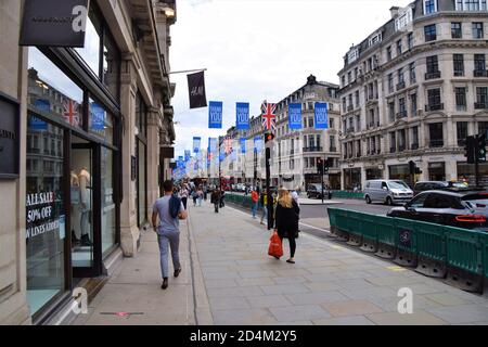 Persone su Regent Street, Londra, con grazie le nostre bandiere di Eroi e barriere di allontanamento sociale, 2020 Foto Stock