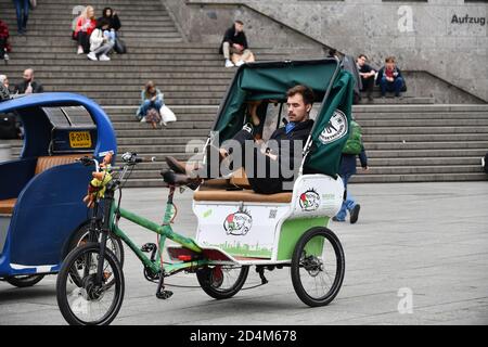 Colonia, Germania, 2020, autista di taxi in bicicletta che si trova fuori dalla stazione ferroviaria di Koln Foto Stock