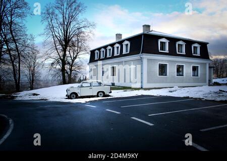 Piccola chiesa vicino alla città di Krnov nella Repubblica Ceca. Auto antica parcheggiata all'esterno. Foto Stock