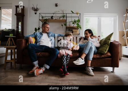Bella famiglia caucasica sul divano insieme godendo di famiglia di qualità ora Foto Stock