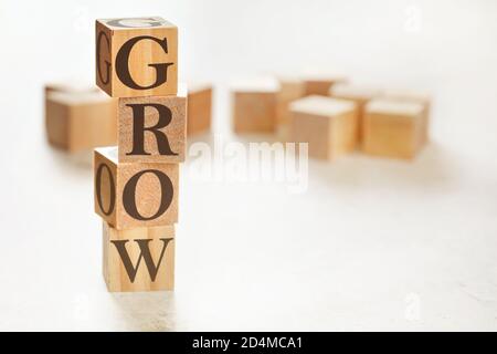Quattro cubi di legno disposti in pila con il testo CRESCONO su di loro, spazio per il testo / immagine in basso a destra angolo Foto Stock