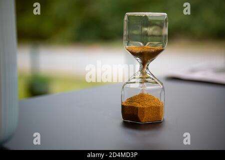 sul supporto da tavolo un orologio a forma di uovo in vetro, che è riempito con piccole palline e corre dritto attraverso Foto Stock