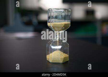 sul supporto da tavolo un orologio a forma di uovo in vetro, che è riempito con piccole palline e corre dritto attraverso Foto Stock