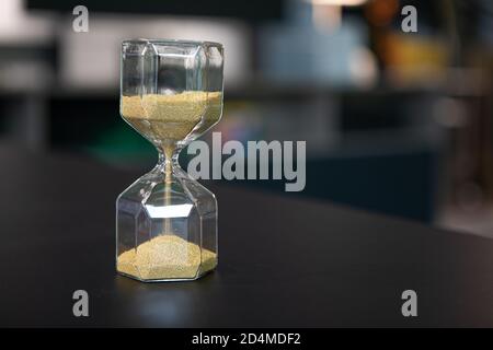 sul supporto da tavolo un orologio a forma di uovo in vetro, che è riempito con piccole palline e corre dritto attraverso Foto Stock