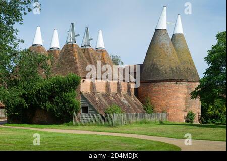 Oast casa edificio progettato per forno (essiccazione) luppolo come parte del processo di produzione. Cielo blu Foto Stock