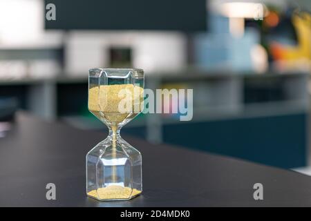 sul supporto da tavolo un orologio a forma di uovo in vetro, che è riempito con piccole palline e corre dritto attraverso Foto Stock