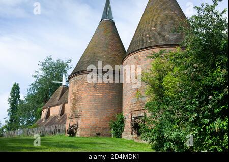 Oast casa edificio progettato per forno (essiccazione) luppolo come parte del processo di produzione. Cielo blu Foto Stock