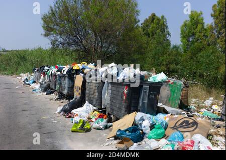 Traboccanti contenitori di rifiuti e lacerati sacchi di spazzatura aperti sul bordo di una strada a causa di uno sciopero da parte del comune di Sicilia, Italia Foto Stock