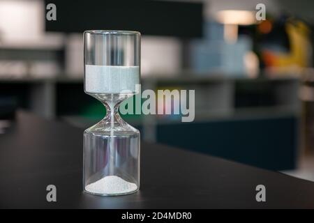 sul supporto da tavolo un orologio a forma di uovo in vetro, che è riempito con piccole palline e corre dritto attraverso Foto Stock