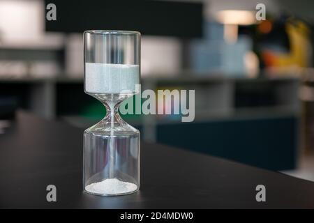 sul supporto da tavolo un orologio a forma di uovo in vetro, che è riempito con piccole palline e corre dritto attraverso Foto Stock