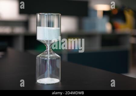 sul supporto da tavolo un orologio a forma di uovo in vetro, che è riempito con piccole palline e corre dritto attraverso Foto Stock