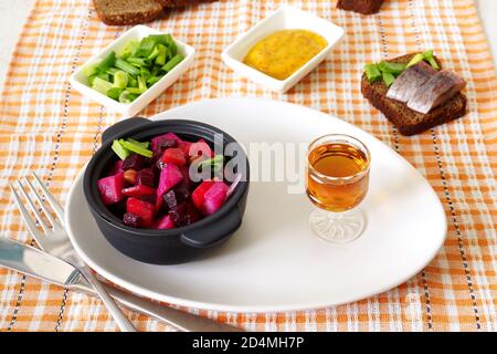 Vinaigrette di insalata russa di barbabietole e un bicchiere di brandy Foto Stock