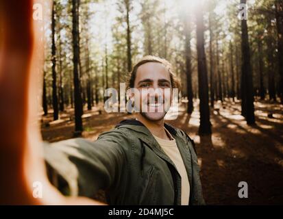 Autoritratto di giovane felice maschio nei boschi, selfie Foto Stock
