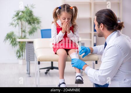 Piccola ragazza che visita giovane medico Foto Stock