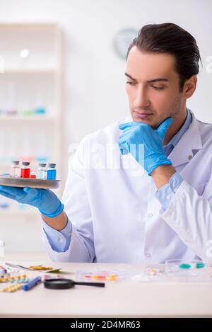 Giovane assistente di laboratorio maschile nel concetto di sintesi del farmaco Foto Stock