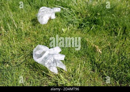 Guanti monouso scartati per strada, in erba. Spazzatura per le strade. Foto Stock