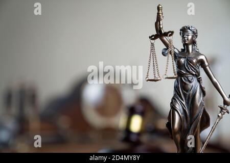 Composizione dei simboli di legge. Gavel del giudice, statua di Themis, scala, clessidra e orologio vecchio sul rustico tavolo marrone in legno. Foto Stock