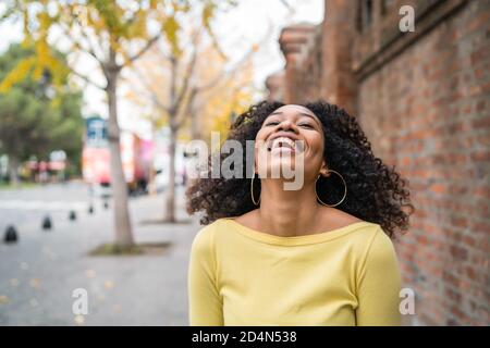 Ritratto di bella giovane afro-americana sicura donna ridendo per strada. All'aperto. Foto Stock