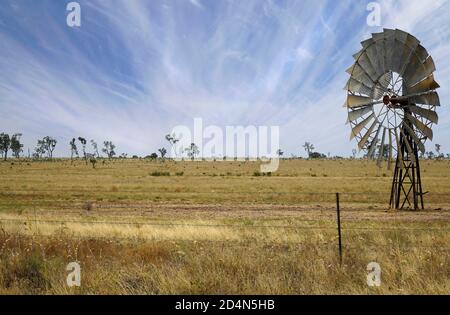 Un mulino a vento nel Queensland Australia con le nuvole ventose Foto Stock