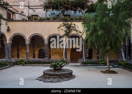 Sorrento - 26 2020 agosto: Chiostri di San Francesco Chiostro o cortile con portico, pozzo e albero Foto Stock