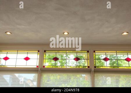 chiusura di vetrate con sezioni rosse e gialle in una bella casa accogliente con una vista verde Foto Stock