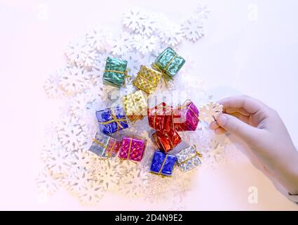 Piccole scatole regalo colorate nelle mani del bambino. Natale e decorazione di NewYear processo. Foto Stock