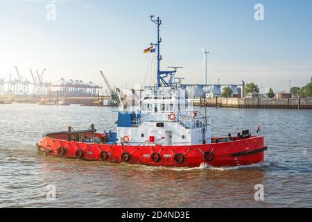 Tugboat rosso sul fiume Elba di fronte al porto di Amburgo, Germania Foto Stock