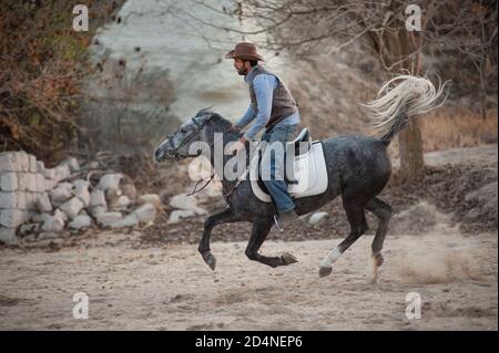 Cappadocia, Turchia. 8 Novembre 2017 Irfan Ozdogan gode di un galoppo sul suo ranch nella Valle di Gorkunde, vicino a Goreme, Cappadocia, Turchia. Foto Stock